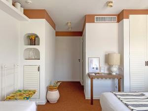 a bedroom with a bed and a desk and a table at Hôtel Le Sud in Juan-les-Pins