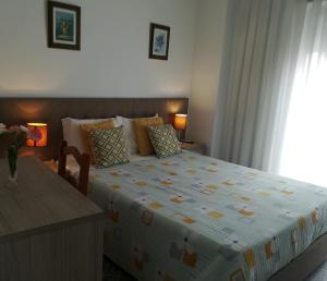 un dormitorio con una cama y una ventana en Hospedaria Sãozinha, en Figueira da Foz