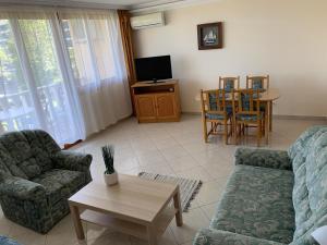 a living room with a couch and a table at Delfin Apartman Balatonfüred in Balatonfüred