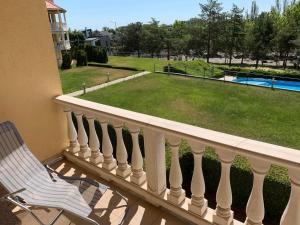 a balcony with a chair and a view of a yard at Delfin Apartman Balatonfüred in Balatonfüred