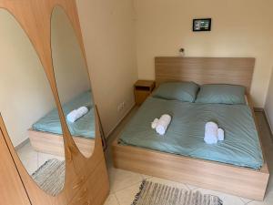 a small bedroom with a bed with a mirror at Delfin Apartman Balatonfüred in Balatonfüred +13 photos