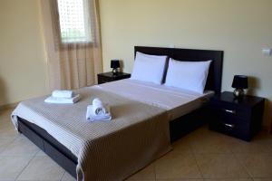 een slaapkamer met een groot bed en handdoeken bij Bouganvillia Olivielias.Air2 in Néon Rýsion