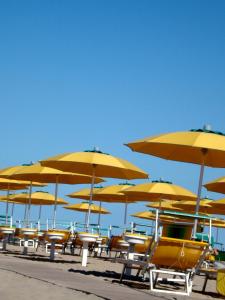 a bunch of chairs and umbrellas on a beach at Mare Home in Cesenatico