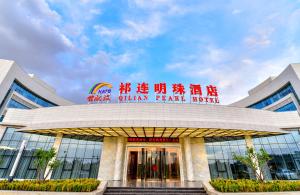 a building with a sign on top of it at Qilian Pearl Hotel Zhangye in Zhangye