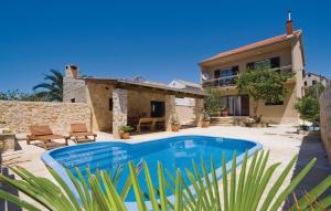 a villa with a swimming pool in front of a house at Holiday house with pool and whirlpool Sara in Betina