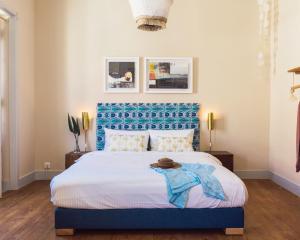 a bedroom with a large bed with a blue headboard at WOT Ericeira Lodge in Ericeira