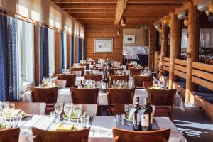 Lapland Hotels Pallas في بالّاستونتوري: صف طاولات في مطعم مع طاولات وكراسي