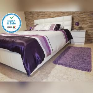 アルブフェイラにあるApartamento Laraのベッドルーム(紫の毛布を使用した大型ベッド1台付)