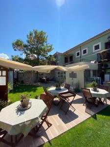a patio with tables and chairs and umbrellas at ZEVKLİLER ALAÇATI hotel in Alacati