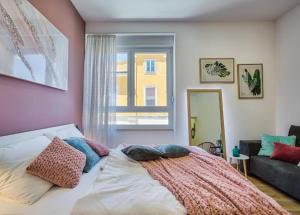 um quarto com uma cama com almofadas e uma janela em Amphitheater Garden Studio Apartments em Pula