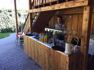 a man sitting at a bar in a wooden building at Apartmány v pivovaru in Kašperské Hory