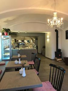 a restaurant with tables and chairs and a chandelier at Apartmány v pivovaru in Kašperské Hory