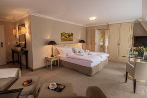 a bedroom with a bed and a living room at Strandhotel Fontana in Timmendorfer Strand