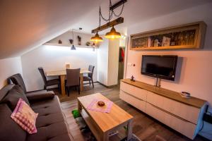 a living room with a couch and a tv and a table at Apartmán Levander in Terchová