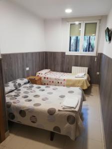 a room with two beds and two windows at Pension Zorroza 1 in Bilbao