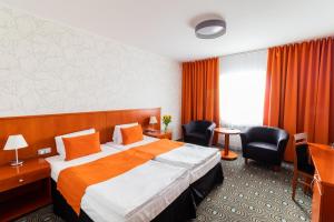 pokój hotelowy z dużym łóżkiem i krzesłami w obiekcie Parkhotel Plzen Congress Center w Pilznie