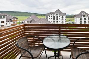 - une table et des chaises sur un balcon avec des bâtiments dans l'établissement The View Zlatibor Hills, à Zlatibor