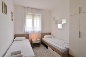 Cette petite chambre comprend 2 lits et une fenêtre. dans l'établissement The View Zlatibor Hills, à Zlatibor