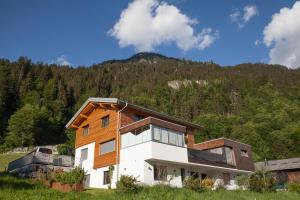 a house with a mountain in the background at Alpenzauber Apartment Montafon in Sankt Gallenkirch
