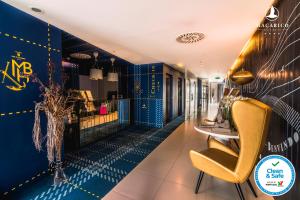 un hall avec des murs bleus et une chaise jaune dans l'établissement Macarico Beach Hotel, à Praia de Mira