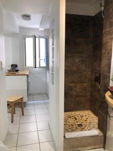 a bathroom with a shower with a stone wall at La Tanière de l'Ours Blanc Aubagne-Cassis-Aix en Provence in Aubagne