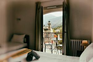 a bedroom with a bed and a view of a balcony at Auberge Saint Martin in La Brigue