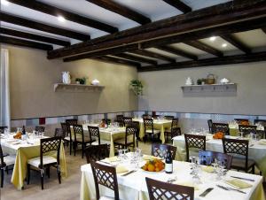 una sala da pranzo con tavoli e sedie bianchi di Hotel Pomara a San Michele di Ganzaria