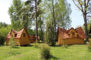 a group of wooden houses in a field with trees at Kargaja Kuke Saun & Kämping in Padakõrve