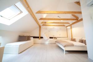 a attic bedroom with two beds and a couch at Apartmány Dačický 2 in Kutná Hora