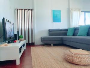 a living room with a blue couch and a tv at Casa do Moinho de Baixo in Sesimbra