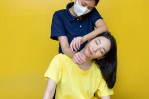 Een vrouw laat haar haar knippen door een vrouw met een masker. bij 128 room and massage in Bangkok