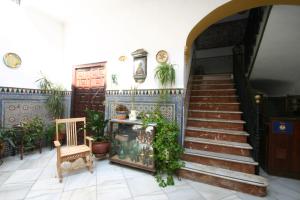 una escalera en una casa con una silla y plantas en Pension el Portillo, en Córdoba