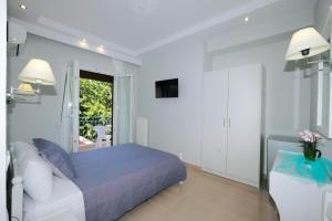 a white bedroom with a bed and a window at Limnia Gi in Myrina
