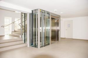 un ascensore in vetro in una casa con scala di FeWo Prora - MeerSonneWind a Binz