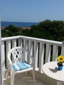 una silla blanca y una mesa en el balcón en Villa Riverside, en Platána