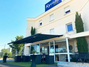 Hôtel Kyriad Brive Ouest في بريف لا غايلارد: فندق أمامه مظله سوداء
