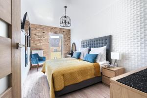 - une chambre avec un lit et une couverture jaune dans l'établissement Art Apartament IMPERO z Parkingiem, à Poznań