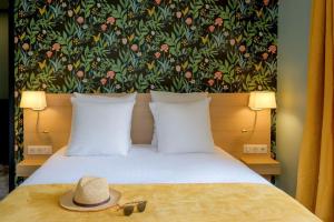 ニースにあるHôtel de France, un hôtel AMMIの帽子が置かれたベッドのある寝室