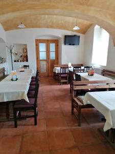 comedor con mesas y sillas y TV en Penzion U Švarců en Zduchovice