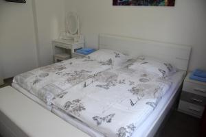 1 dormitorio con 1 cama con colcha blanca en Geräumige 4 Zimmer Wohnung an den Kaiserthermen, en Trier