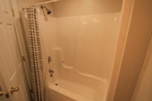a white bathroom with a shower and a tub at Superp South End Apartment in Burlington +12 photos