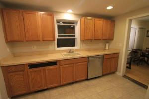a kitchen with wooden cabinets and a sink and a window at Superp South End Apartment in Burlington