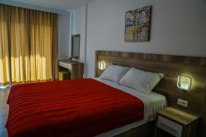 a bedroom with a large bed with a red blanket at BUZUKU Apartments Liman (Mediterraneo) in Ulcinj