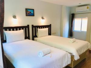 En eller flere senge i et værelse på Baan Chang Residence