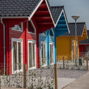 a row of colorful houses in a row w obiekcie Luxe Chalets in Zeeland aan de kust w mieście Sint Annaland
