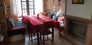 a living room with a table and a fireplace at Под старата липа in Goritsa +16 photos