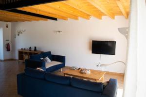 a living room with two blue couches and a tv at Quinta David in Alvor
