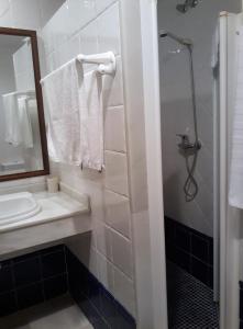 uma casa de banho branca com um lavatório e um espelho em Hostal Artiga em Alborea