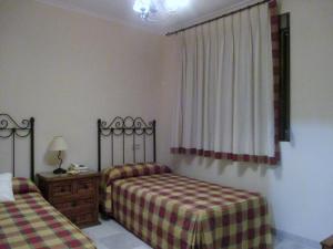 1 dormitorio con 2 camas individuales y ventana en Hostal Artiga, en Alborea