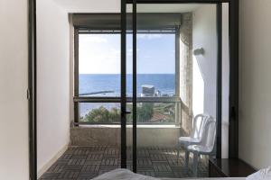 a bedroom with a view of the ocean from a window at Hotel Blue Weiss in Netanya